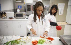 Lockeed Martin research scientist Maya Cooper, left, and Monica Leong, right, prepare a vegan pizza